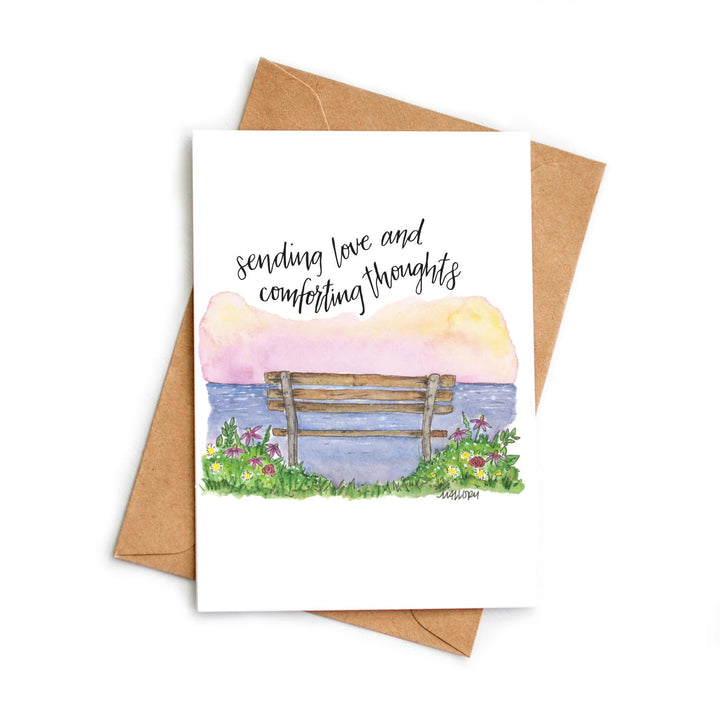 Greeting card with a bench and flowers on a watercolor background, featuring the text 'sending love and comforting thoughts'.