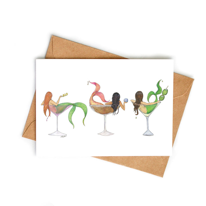 Greeting card with mermaid illustrations in martini glasses on a white background