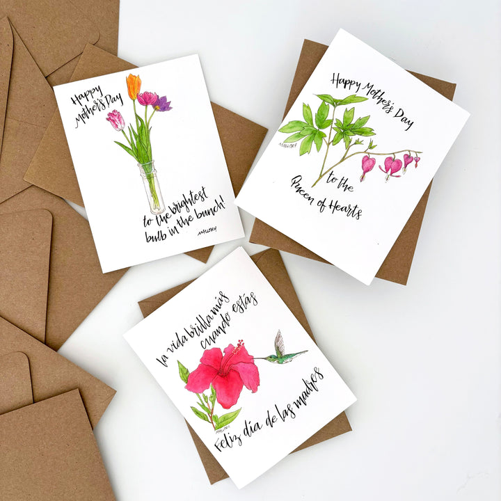 Three Mother's Day cards with floral designs on a white background with brown envelopes.