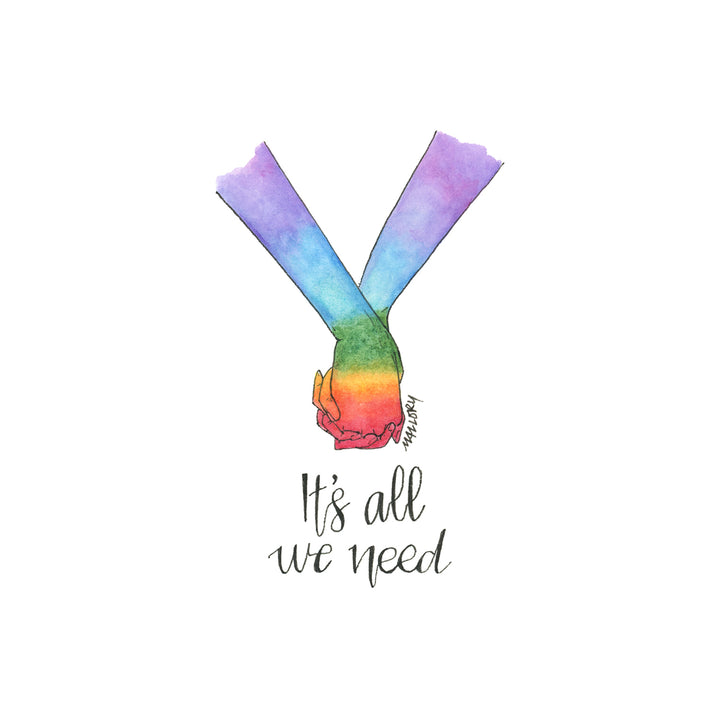 Image of a pride card to show support for LGBTQ+. Hand-drawn card shows two holding hands that are painted with the pride rainbow with the words, "It's all we need" lettered below.