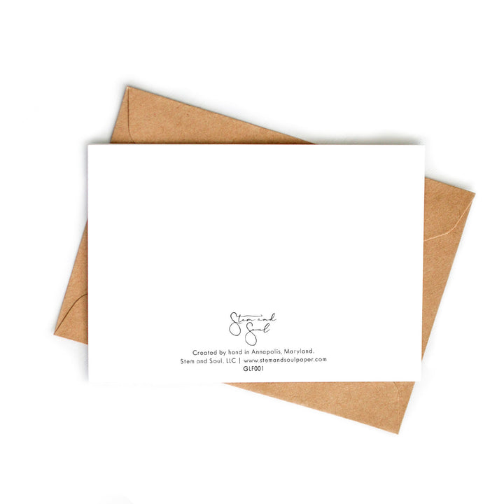 Image of a blank greeting card atop a recycled kraft envelope