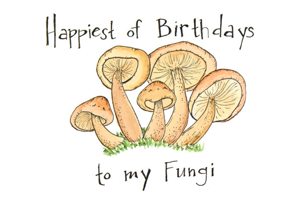 Image of a birthday card with mushrooms in the grass. The words "Happiest of birthdays to my fungi" are hand-lettered on the card.