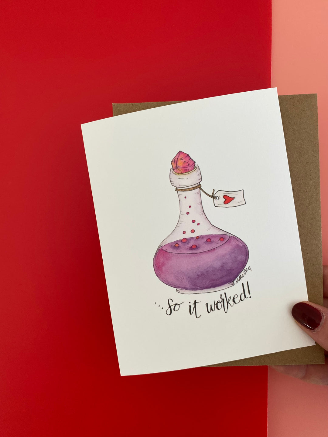 Valentine's Day card shows a purple and pink bubbling love potion inside a fancy glass bottle. The bottle is sealed with a glowing pink crystal and a tag with a red heart on it. Below the words, "...so it worked!" referring to the love potion.