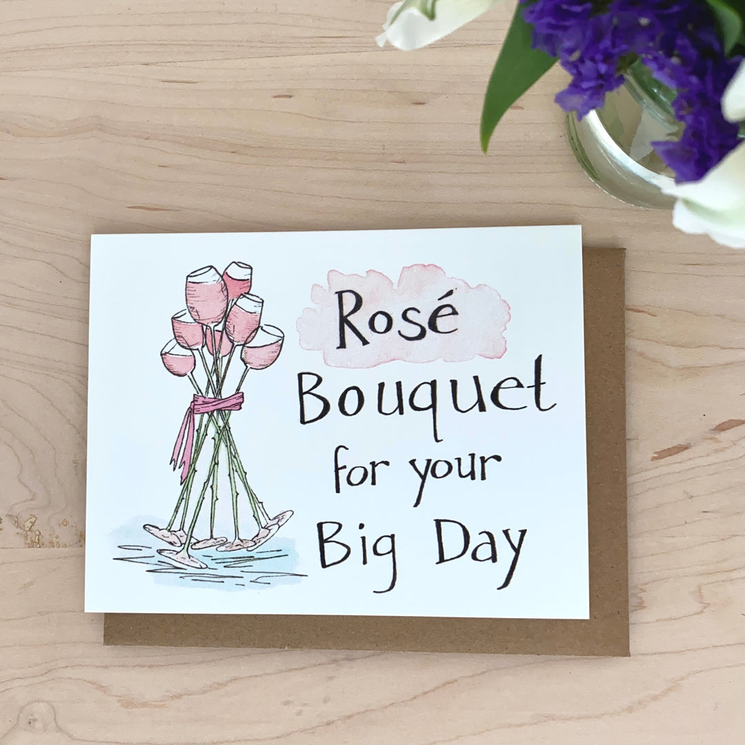 Image of a bouquet of glasses of rosé wine that are tied together with a pink ribbon. The words, "Rosé bouquet for your big day" are hand-lettered on the card.