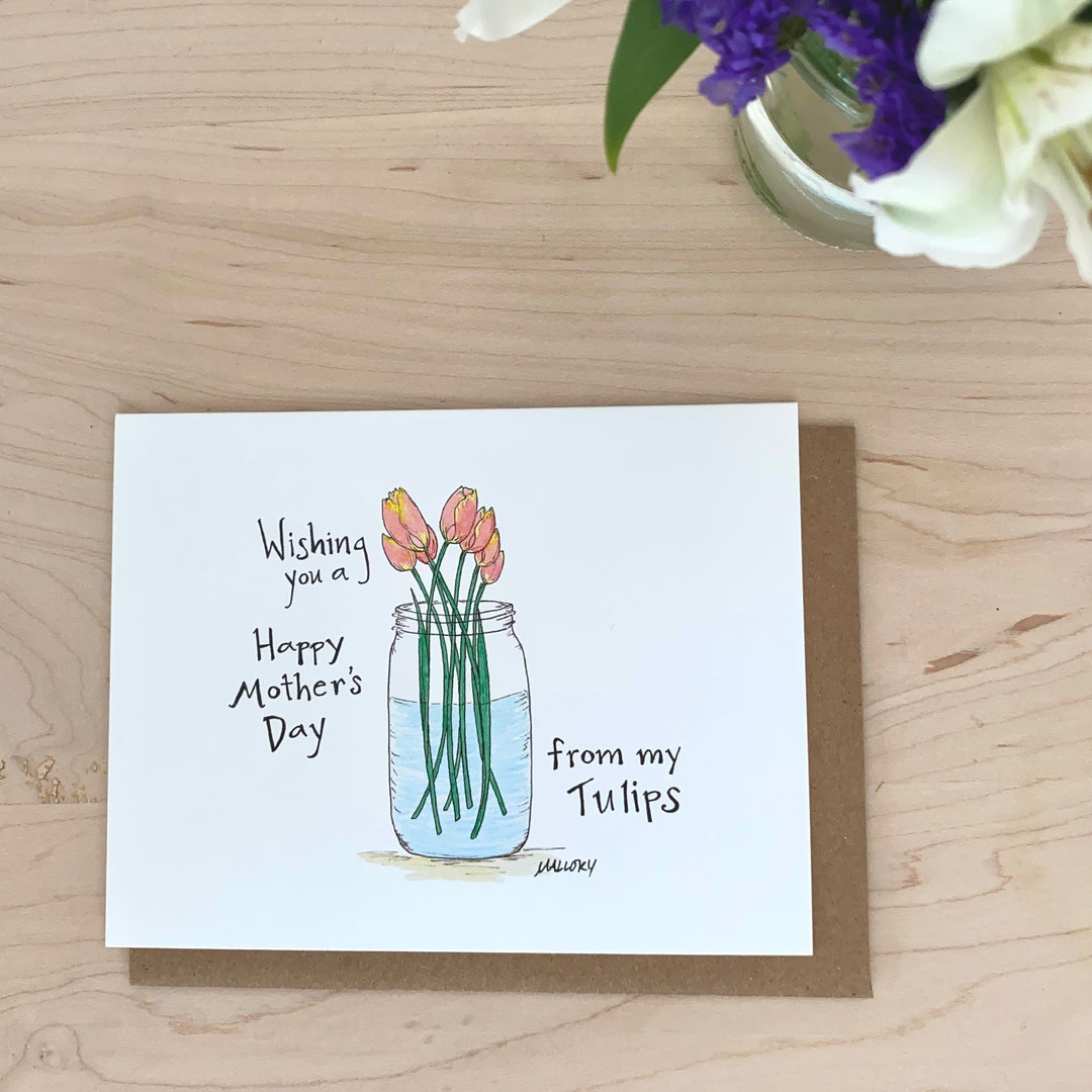 Image of a Mothers Day card with pink tulips in a mason jar. The words "Wishing you a Happy Mother's Day from my Tulips" is hand-lettered on the card.