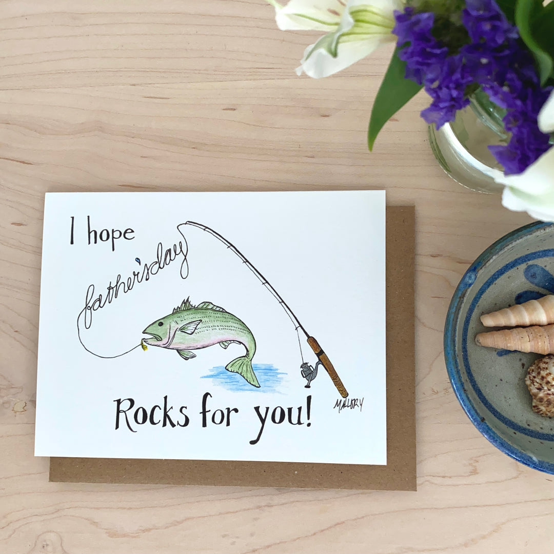 Image of a Father's Day card for a fisherman dad, image of a hand-painted rockfish on a fishing rod with the words, "I hope Father's Day rocks for you" are hand-lettered on the card.