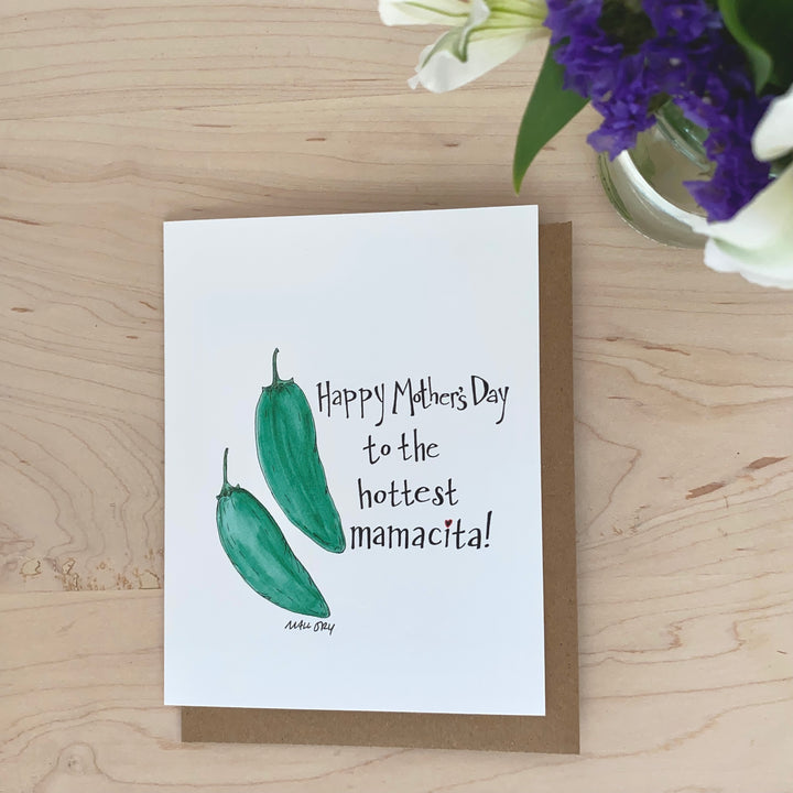 Image of a Mother's Day card for new moms with green jalapeño peppers. The words, "Happy Mother's Day to the hottest mamacita!" are hand-lettered on the card.